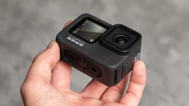 best action camera being held above a grey path