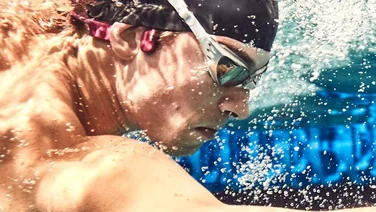 Shokz Open Swim headphones being worn by a swimmer
