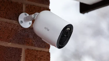 The Arlo Go 2 security camera mounted on a red brick exterior wall