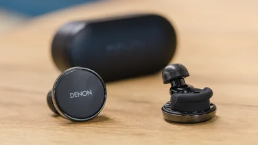 Denon PerL Pro review - earbuds in front of charging case