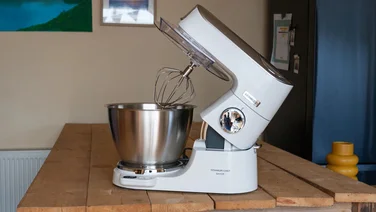 A white stand mixer on a wooden countertop