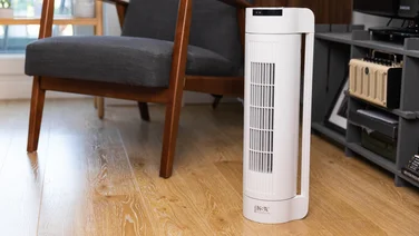 An NSA Dual Position tower fan next to an arm chair