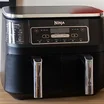 Ninja Foodi Max Dual Zone on a wooden work top with a white wall behind