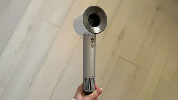 Dyson Supersonic in white photographed in front of a light wooden floor