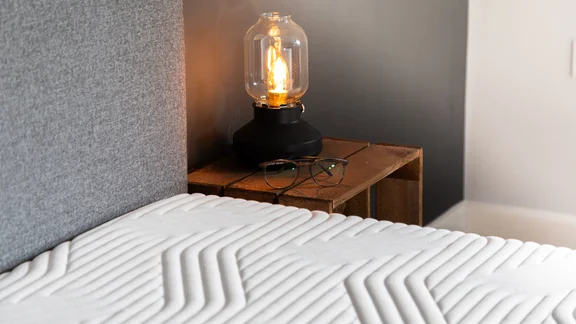 Tempur supreme memory foam mattress next to a wood bedside table