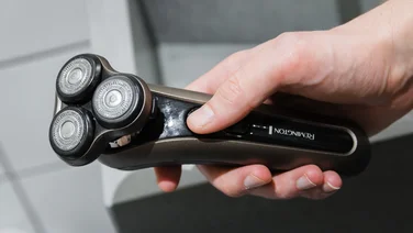 Close-up photograph of an electric shaver next to a sink