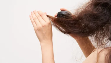 Person brushes out frizzy static hair