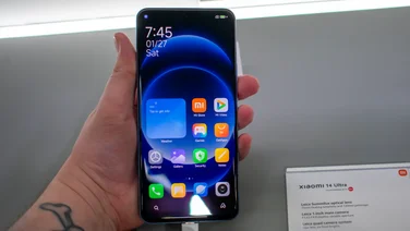 Xiaomi 14 Ultra front view, in hand, grey bench in the background