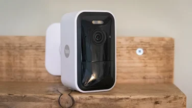 yale smart outdoor camera in white on a wooden table front facing