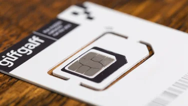 A white Giffgaff SIM card on a wooden table
