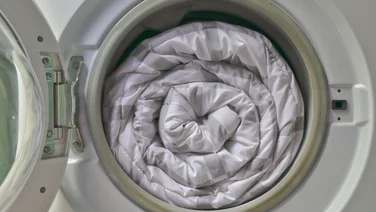 Image of a rolled up duvet/blanket inside of a washing machine
