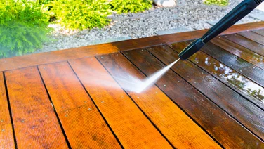 man cleaning decking with pressure washer outside how to clean decking with a pressure washer