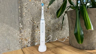 how to clean an electric toothbrush lead image of an oral b toothbrush on a wooden countertop