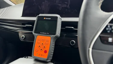 foxwell nt680 review - positioned in car with steering wheel in background