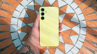 Samsung Galaxy A35 5G in hand, rear view, with an orange and white mosaic table in the background