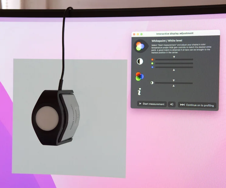 how we test monitors teaser pink background on screen with a brightness tester on the monitor