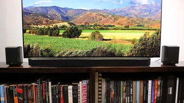 samsung_hw_q990d_review- Image displaying the soundbar placed in front of the television resting on a bookshelf