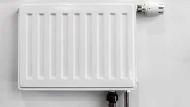 How to balance your radiators - featured. A small radiator on a white wall