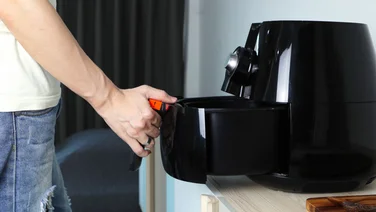 man removing air fryer basket from counter - can i put an air fryer basket in the dishwasher