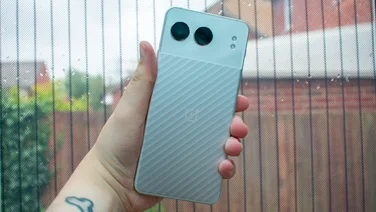 OnePlus Nord 4, rear view, in hand in front of a window