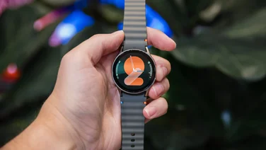 Image of a hand holding the Samsung Galaxy Watch 7 from a front on perspective
