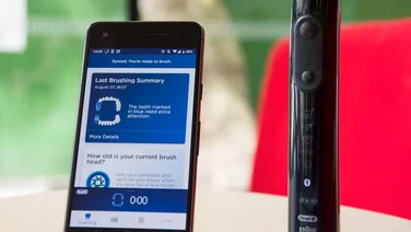 an image of the oral b genius x toothbrush with its tracking app