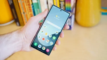 Samsung Galaxy Z Fold 6 in hand, folded with the display on, in front of a bookcase