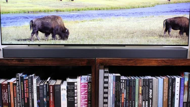 Front view of the LG US95TR soundbar underneath the LG C4 OLED TV