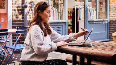 Woman using Microsoft Surface Pro at a picnic table