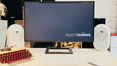 The Philips 27E1N1600AE pictured on a desk with a pair of speakers and typewriter to the left