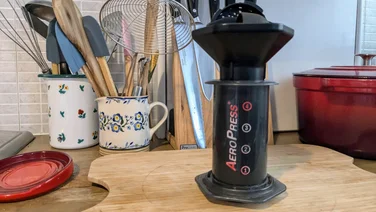 An image of an aeropress on a chopping board in a kitchen