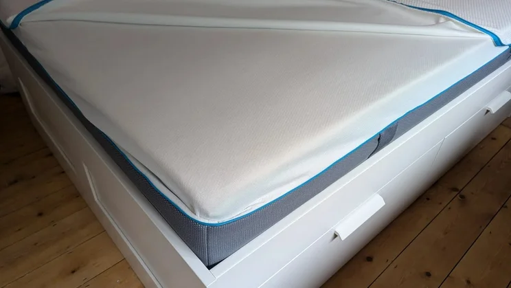 A corner of the Simba Hybrid Pro on a bed frame