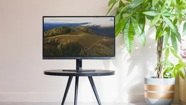 AOC 27G4XE pictured on a circular table with a plant to the right