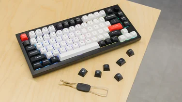 Keychron Q1 HE pictured on a desk with spare keys and key puller tool