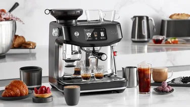 Sage Oracle Jet coffee machine sat on counter with coffees and pastries