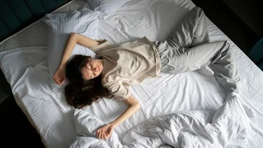 A bird's eye view of a person sleeping on a mattress