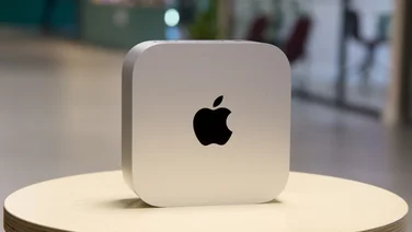 The Mac mini (2024) pictured on a small stool in an office environment