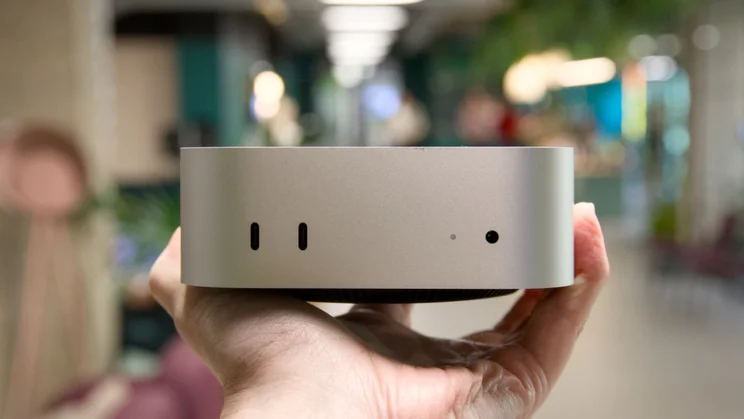 The Mac mini (2024) held in the palm of a hand