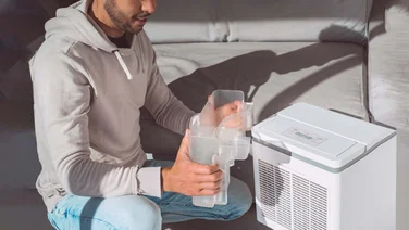 A man holding a dehumidifier tank full of water