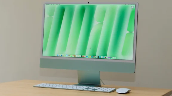 The M4 Apple iMac in green, pictured on a wood table with matching keyboard and mouse