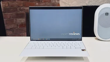 The Dell XPS 13 9345 with Snapdragon on a white table with a brick fireplace in the background
