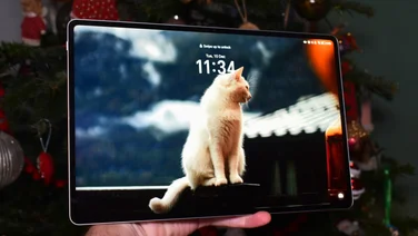 Honor Magic Pad 2 in hand with the display on, in front of a Christmas tree