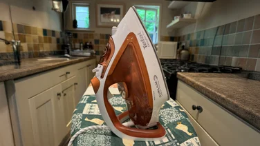 Tefal Easygliss Eco FV5782 steam iron review header on a ironing board in a kitchen