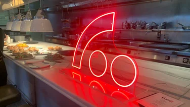 Image of a Neon Freely logo on the counter at Lina Stores, King's Cross