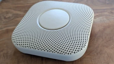 The Google Nest Protect 2nd Gen, pictured on a wooden table top