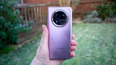 Honor Magic 7 Lite in hand, rear view, in front of a frost-covered garden