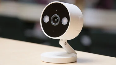 The Tapo C120 pictured on a wood tabletop