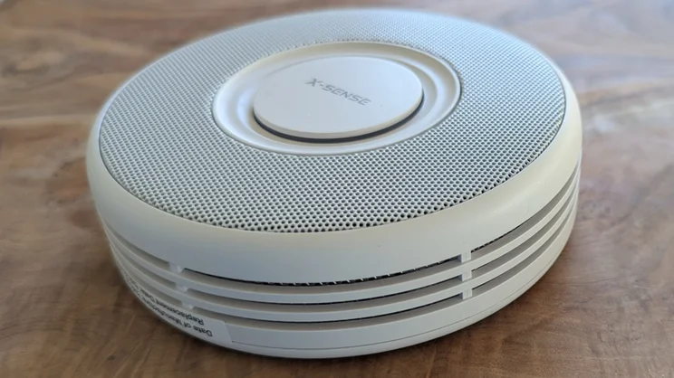 X-Sense Link+ Pro smoke alarm pictured on wood surface