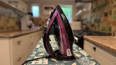 Tefal Ultimate Pure FV9830 steam iron review standing side view on a colourful ironing board