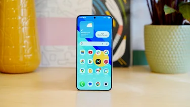 Samsung Galaxy S25 Plus standing on a table, display on showing the home screen